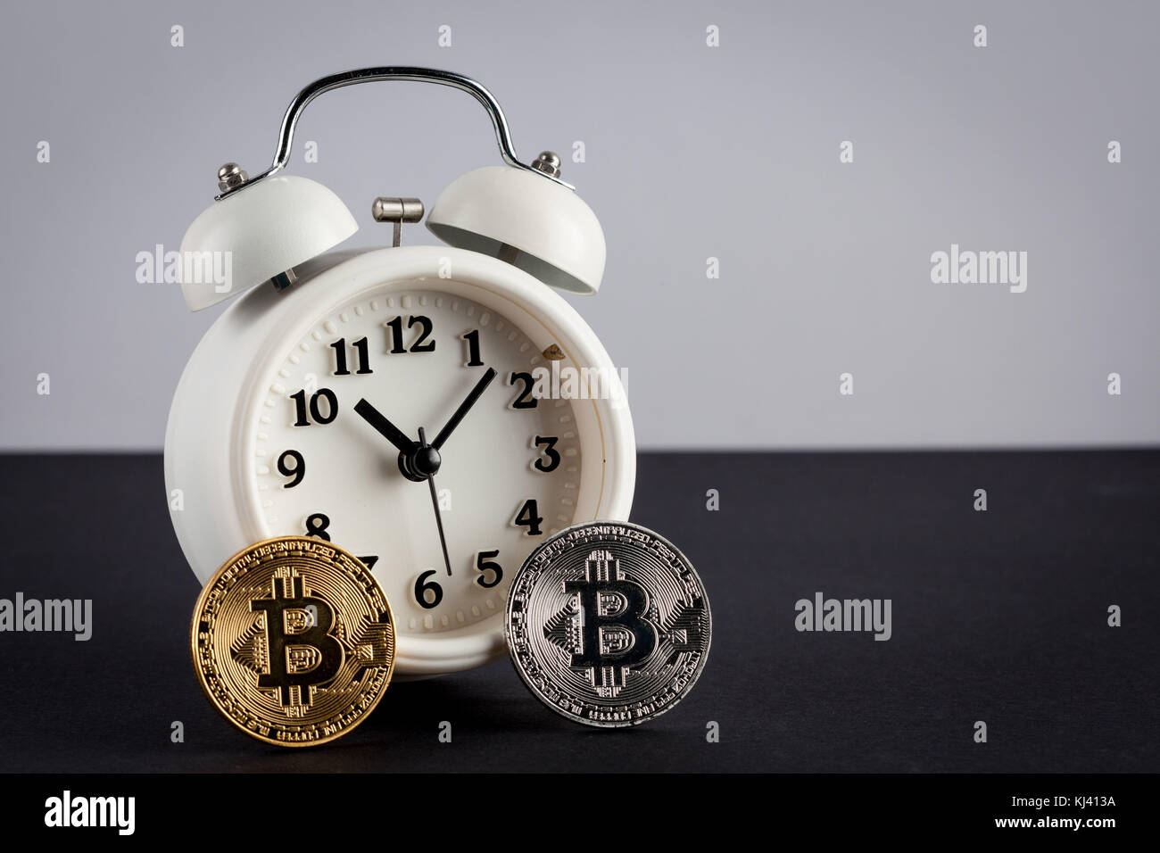 Two bitcoins and vintage alarm clock with copy spaces. Cryptocurrency