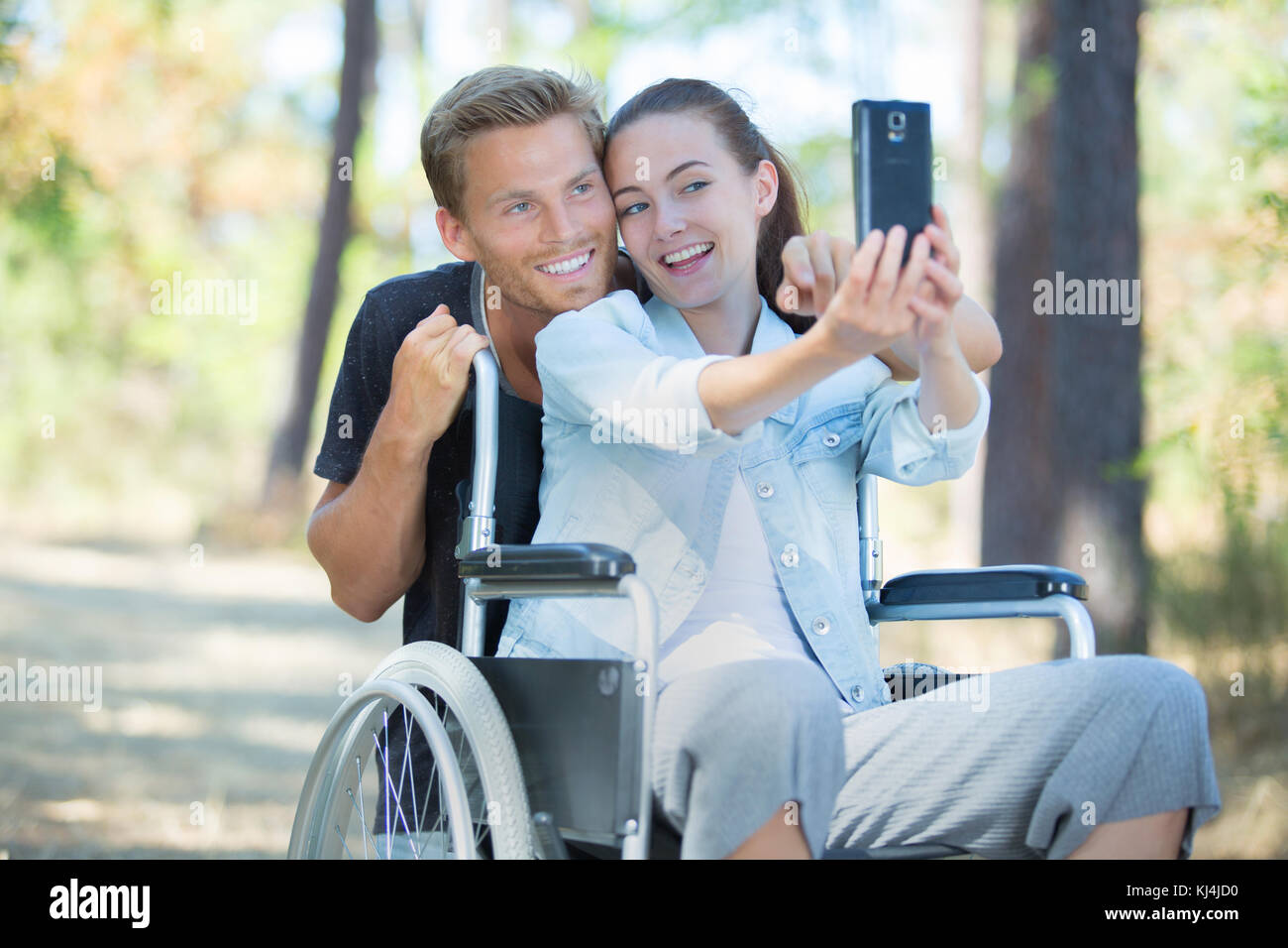 woman in wheelchair and boyfriend taking a selfie with smartphone Stock ...