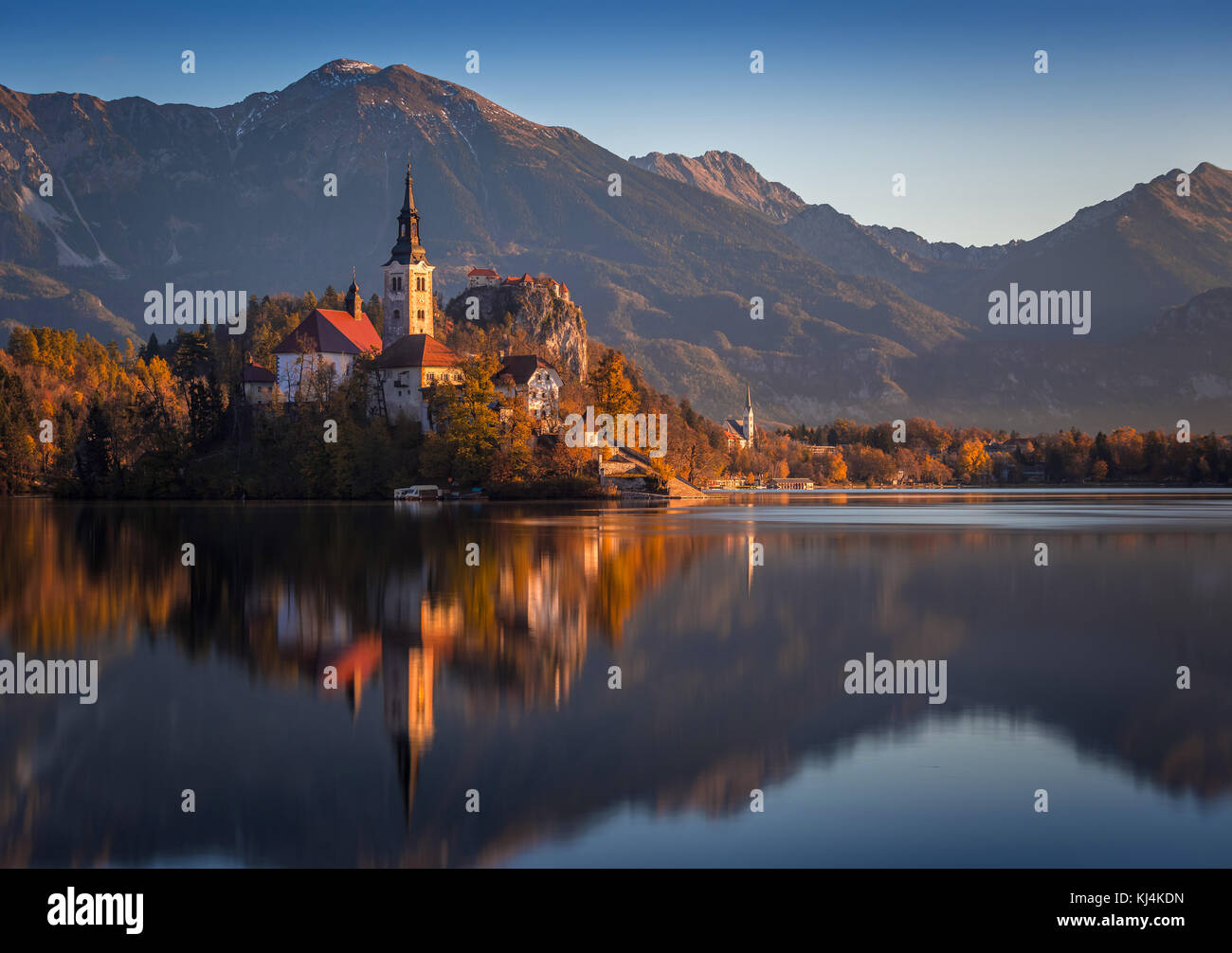 Bled, Slovenia - Beautiful autumn sunrise at Lake Bled with the famous Pilgrimage Church of the Assumption of Maria and Bled Castle and Julian Alps at Stock Photo