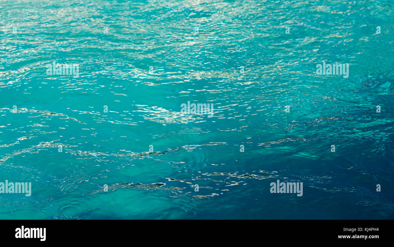 Aquamarine water in an outdoor swimming pool in summer is