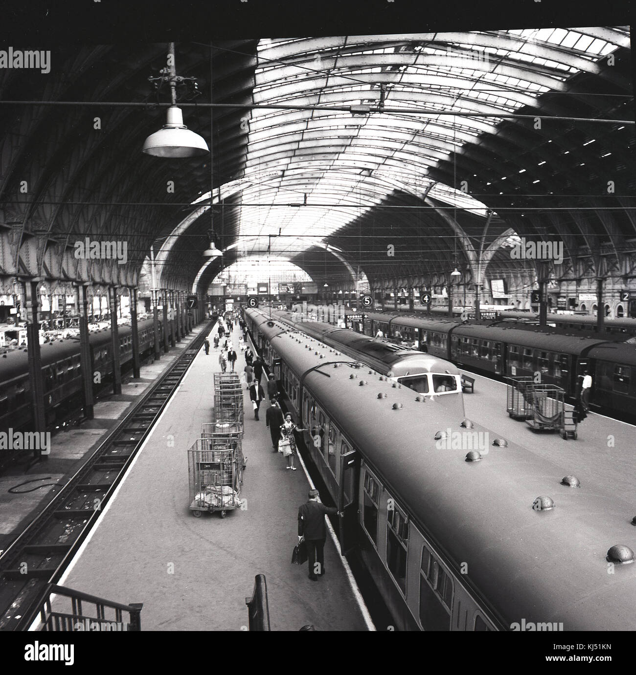 1950s, historical picture showing the Victorian train shed with glazed roof at London's Paddington Railway Station, with trains waiting for boarding passengers at platforms, Praed Street, London, England, UK. Stock Photo