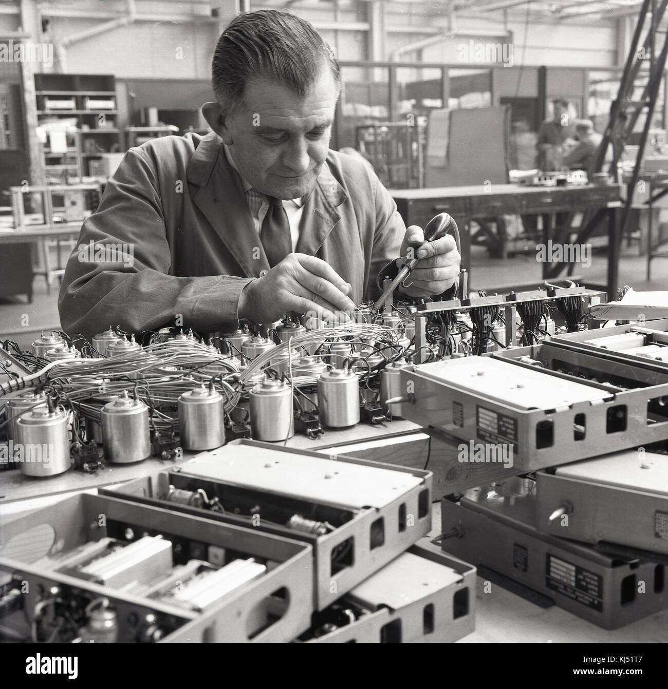 1950s, historical, a male worker soldering wires to metal units. Stock Photo
