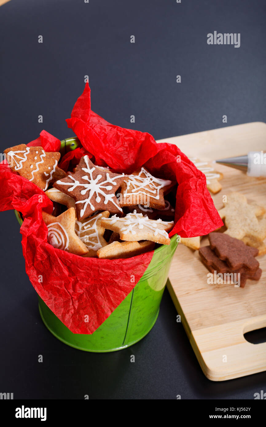 Idea DIY Do it yourself new year and Christmas gift concept butter sugar cookies with royal icing decoration in green bucket with copy space Stock Photo