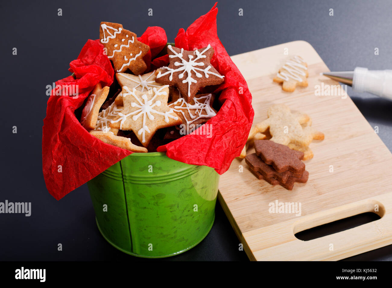 Idea DIY Do it yourself new year and Christmas gift concept butter sugar cookies with royal icing decoration in green bucket with copy space Stock Photo