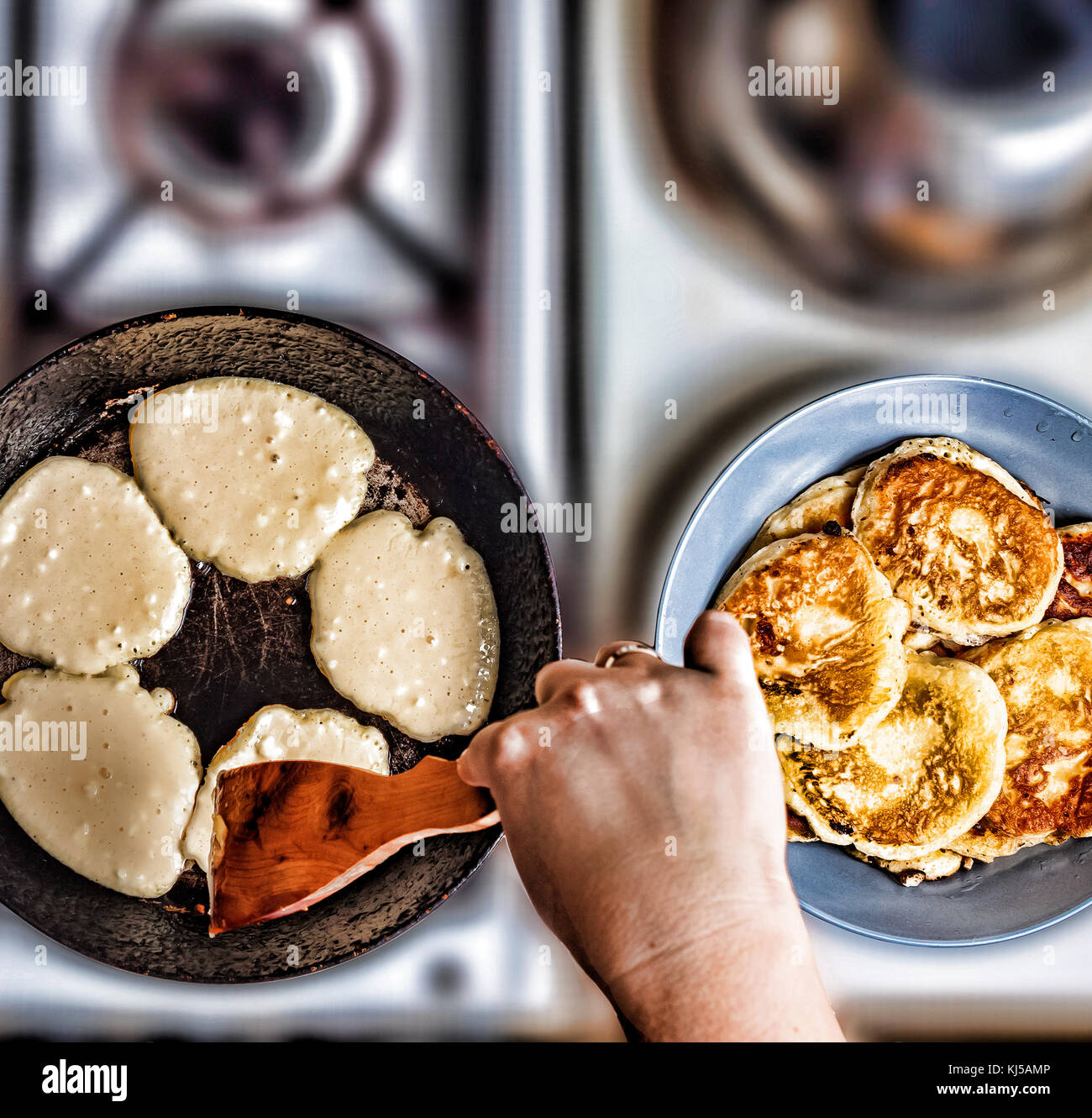 Woman fry pancakes in a frying pan on an old gas stove. Concept