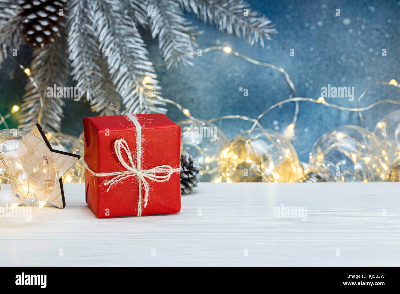 glowing retro light garlands, gift box and blurred christmas tree ...