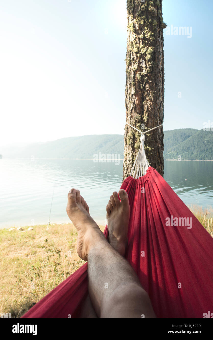 Man in hammock on mountain lake shore Stock Photo Alamy