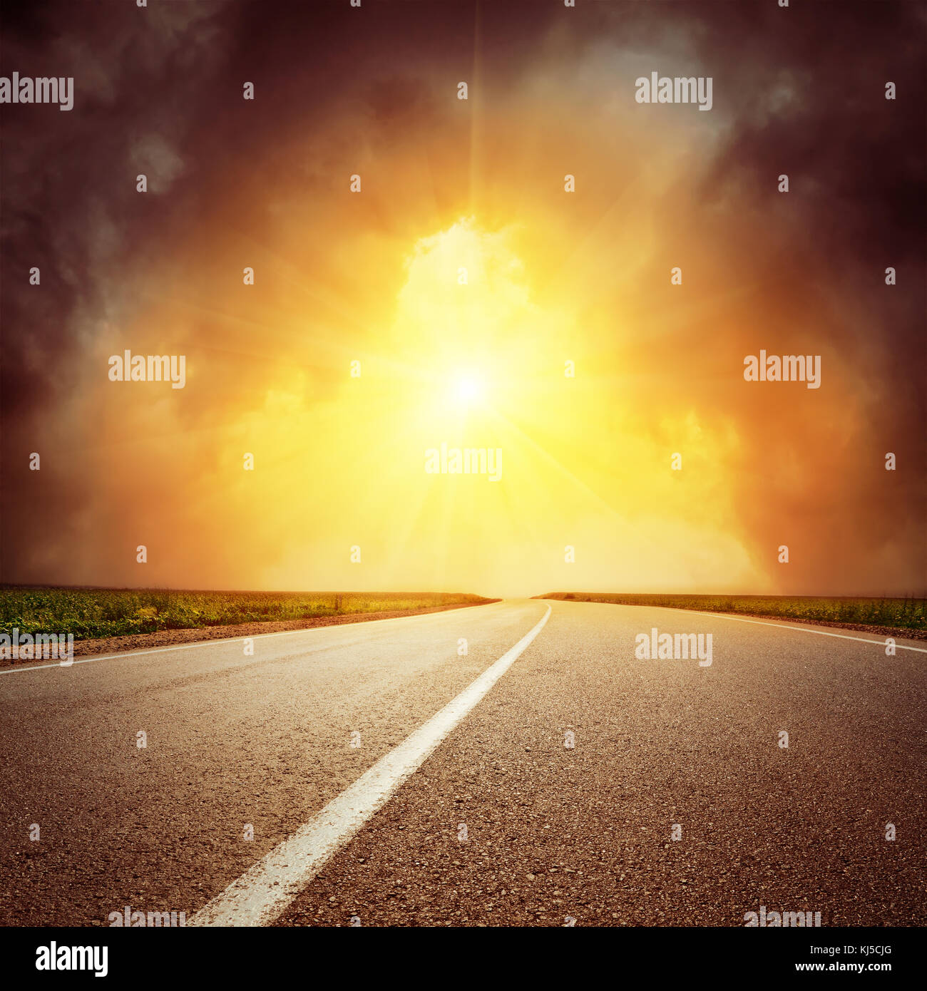 asphalt road to horizon and sunset in dramatic low clouds Stock Photo ...