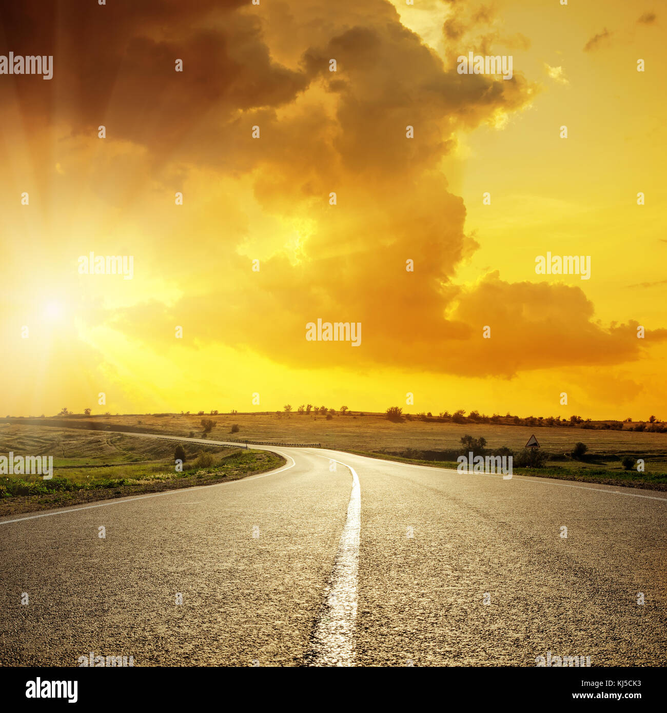 orange sunset in clouds over asphalt road Stock Photo - Alamy