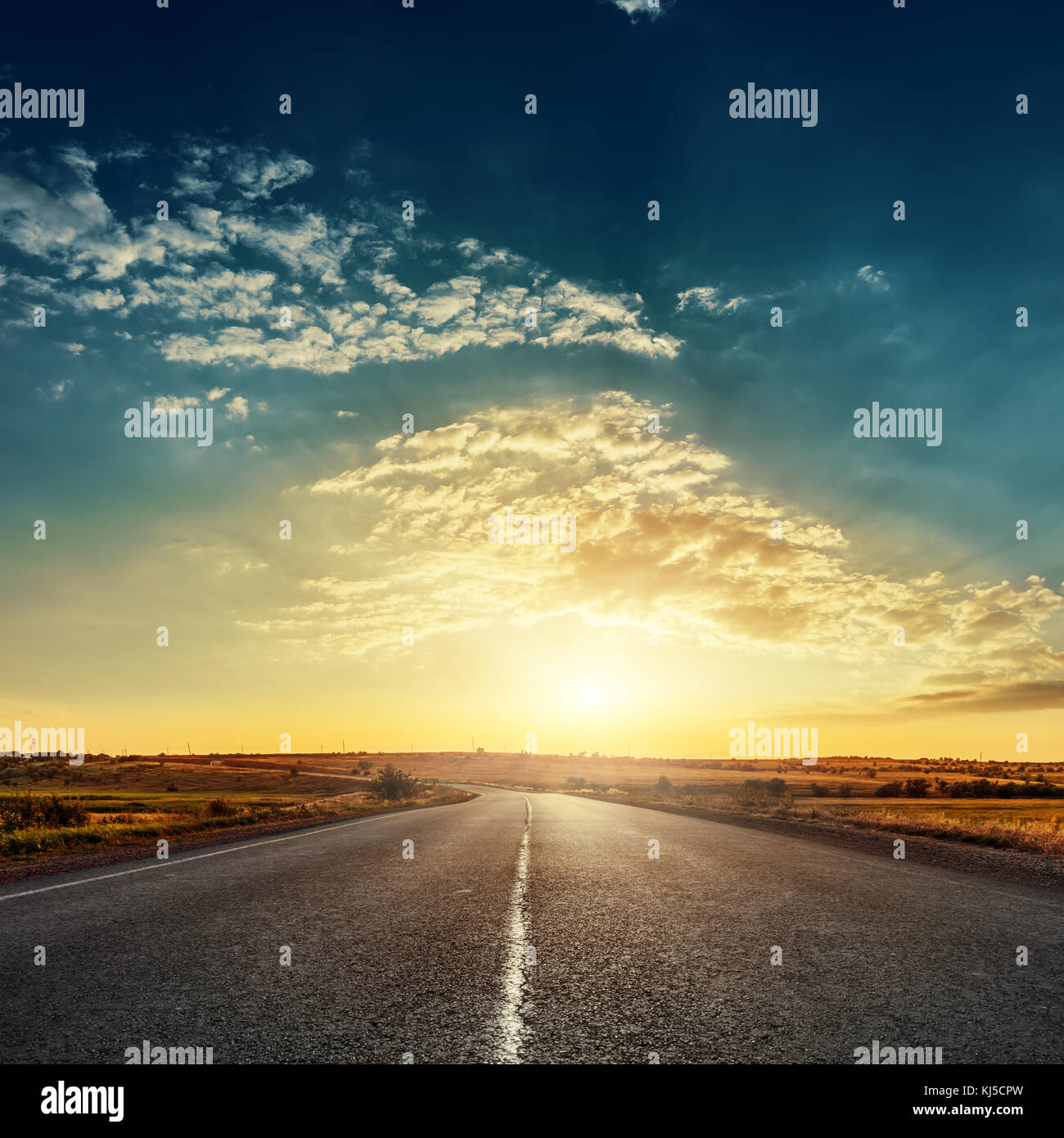 low sun in dramatic sky over asphalt road Stock Photo - Alamy
