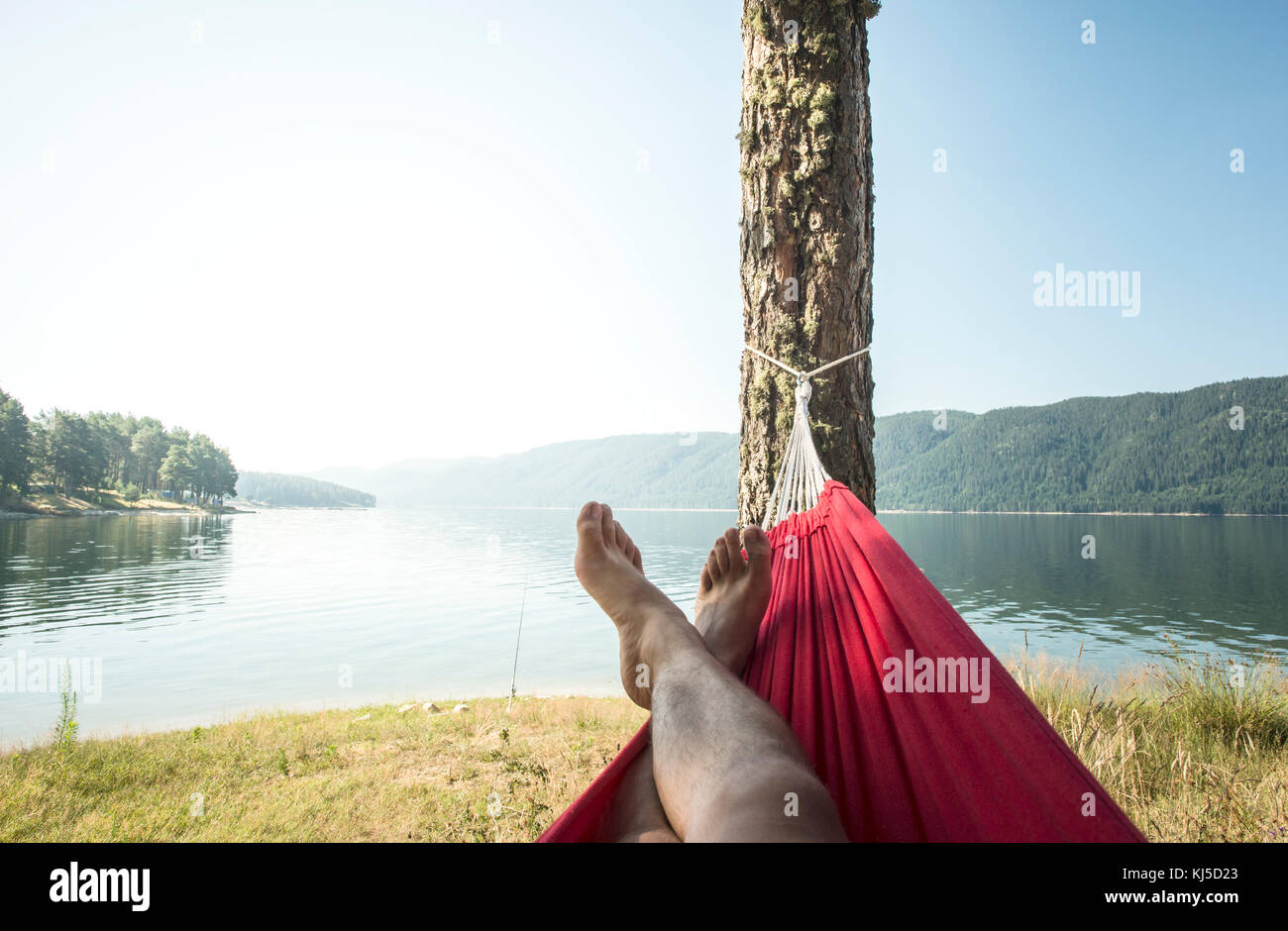 Man in hammock on mountain lake shore Stock Photo Alamy