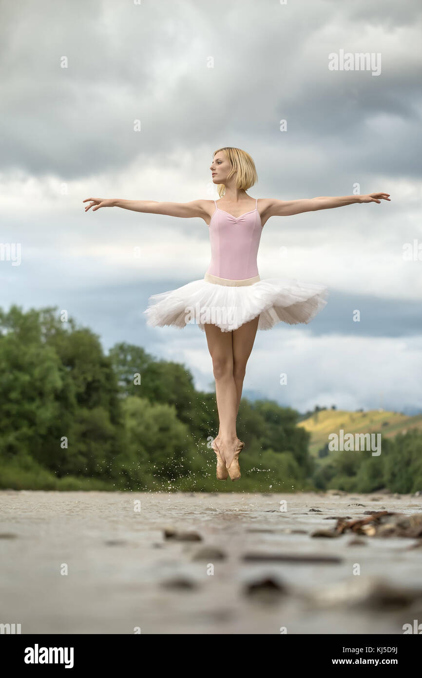 Ballerina jumping above river Stock Photo