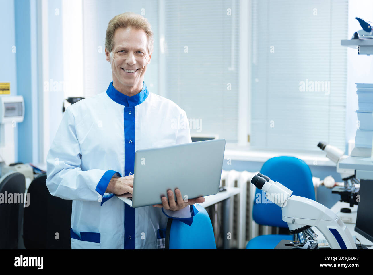 Smiling researcher holding a tablet Stock Photo - Alamy