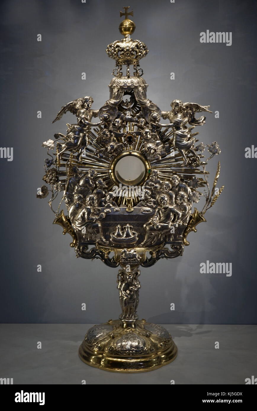 Silver and gilded Monstrance, 1705, by Johannes Zeckel (active 1691-1728); Augsburg, Germany, A monstrance displayed the Sacred Host the consecrated bread which in Catholic belief is the body of Christ. The word comes from the Latin monstrare, to show. This example embodies Counter Reformation theology. In the centre is the Last Supper with the disciples seated at the table. Christ himself is represented only when the Host is placed inside the window. The rays of the sun represent his radiance. The corn and grapes on either side refer to the bread and wine of the Mass, which become his body an Stock Photo