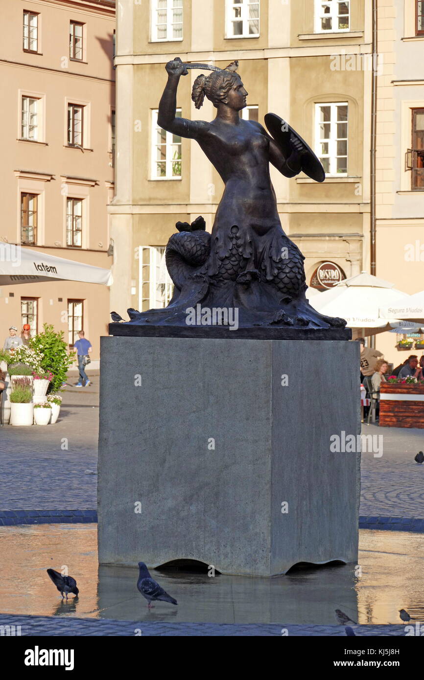 The Mermaid sculpture in the Old Town Square, Warsaw, Poland, was designed by Varsovian sculptor, Konstanty Hegel. There are various legends about the Warsaw mermaid. The main one used in the City's literature and by tour guides says that the mermaid was swimming in the river when she stopped on a riverbank near the Old Town to rest. Liking it, she decided to stay. Stock Photo