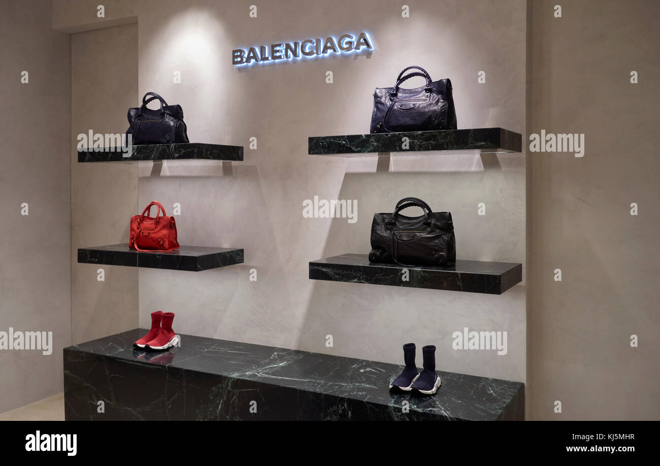 Elegant fashion store, Balenciaga bags and leather shoes on the shelves Stock Photo