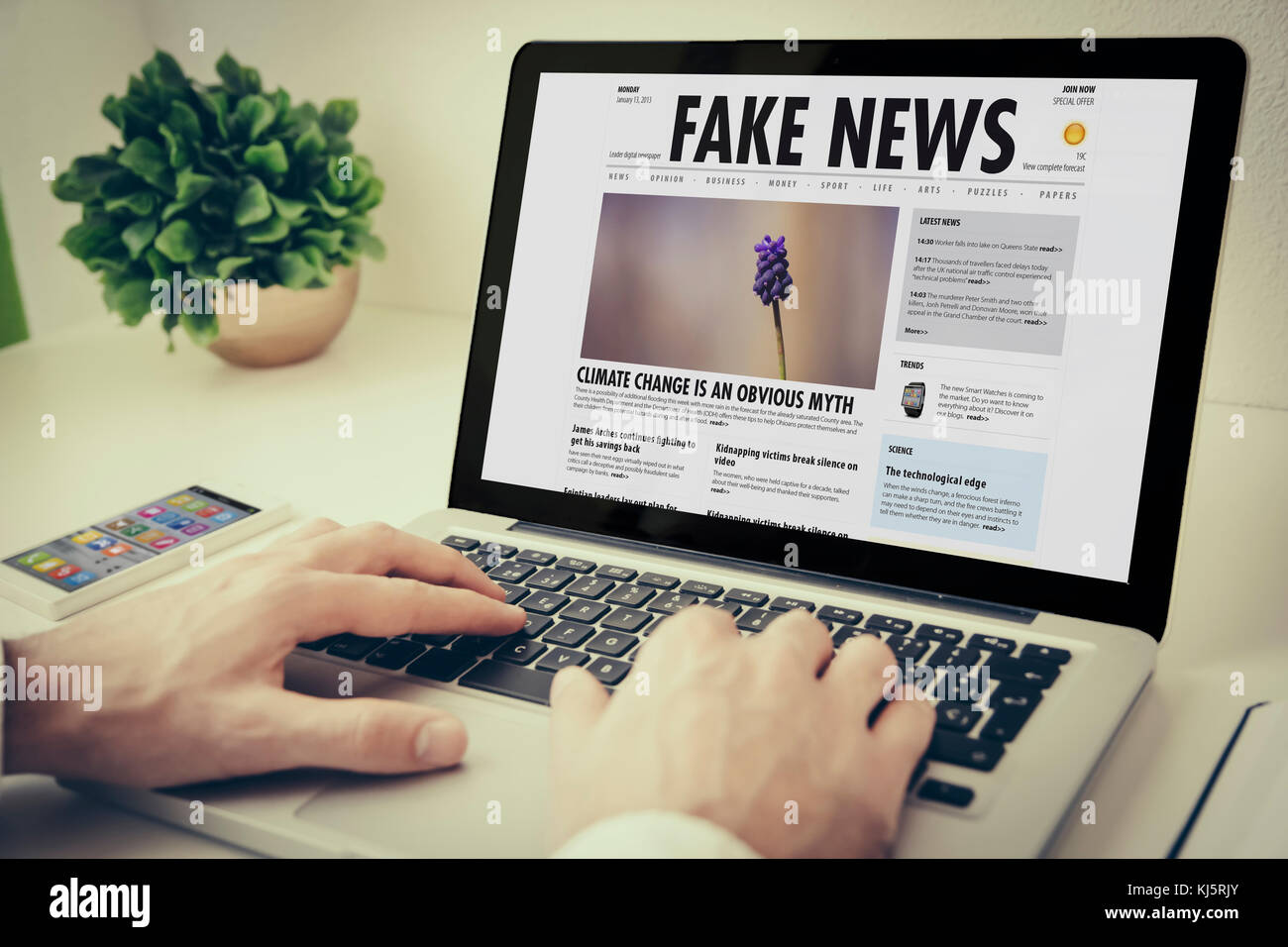 Hands using laptop on desktop with fake news Stock Photo