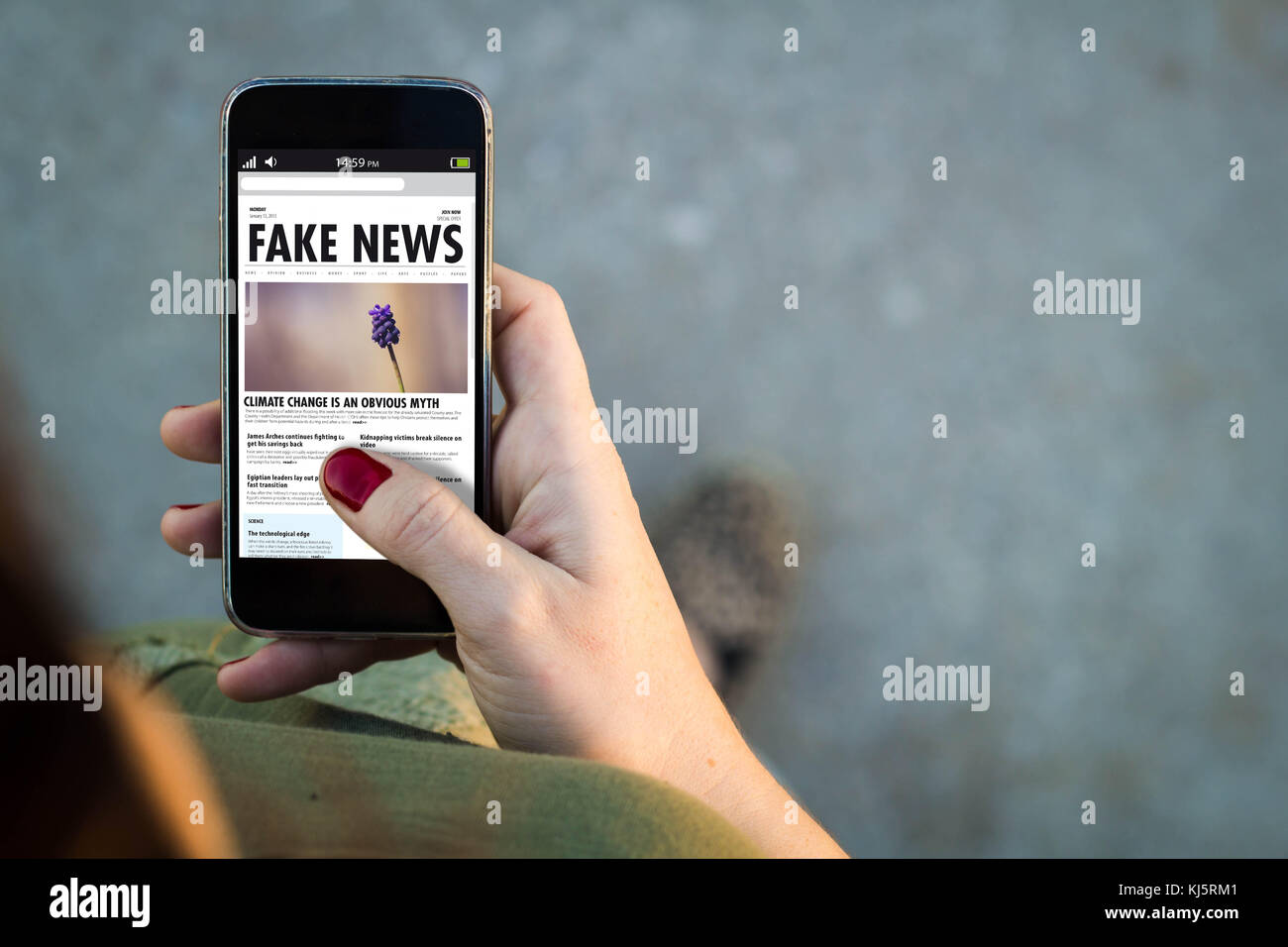 Top view of woman walking in the street using her mobile phone with fake news. All screen graphics are made up. Stock Photo
