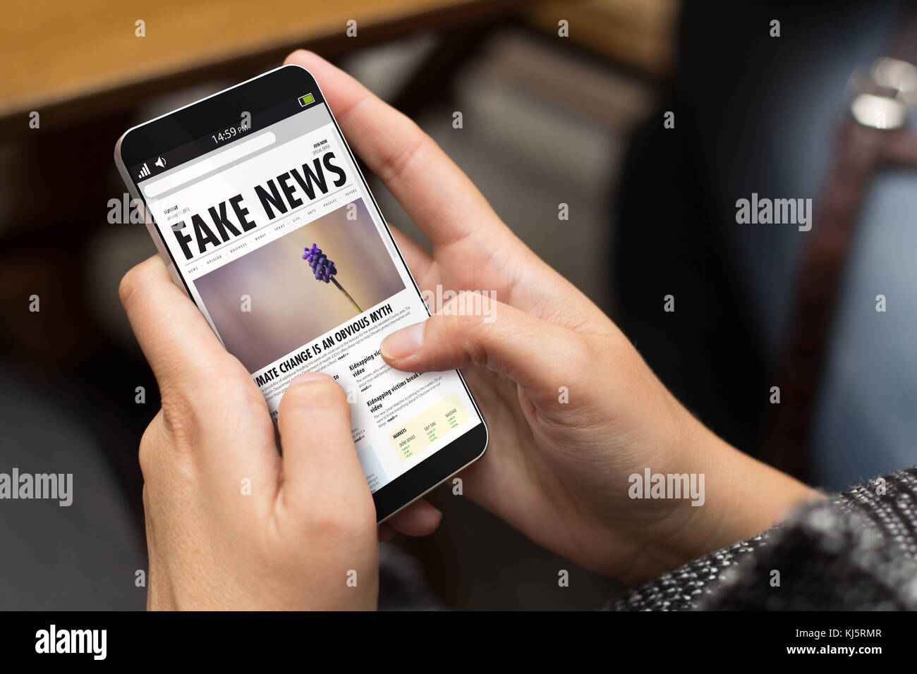 information concept: girl using a digital generated phone with fake news on the screen. All screen graphics are made up. Stock Photo