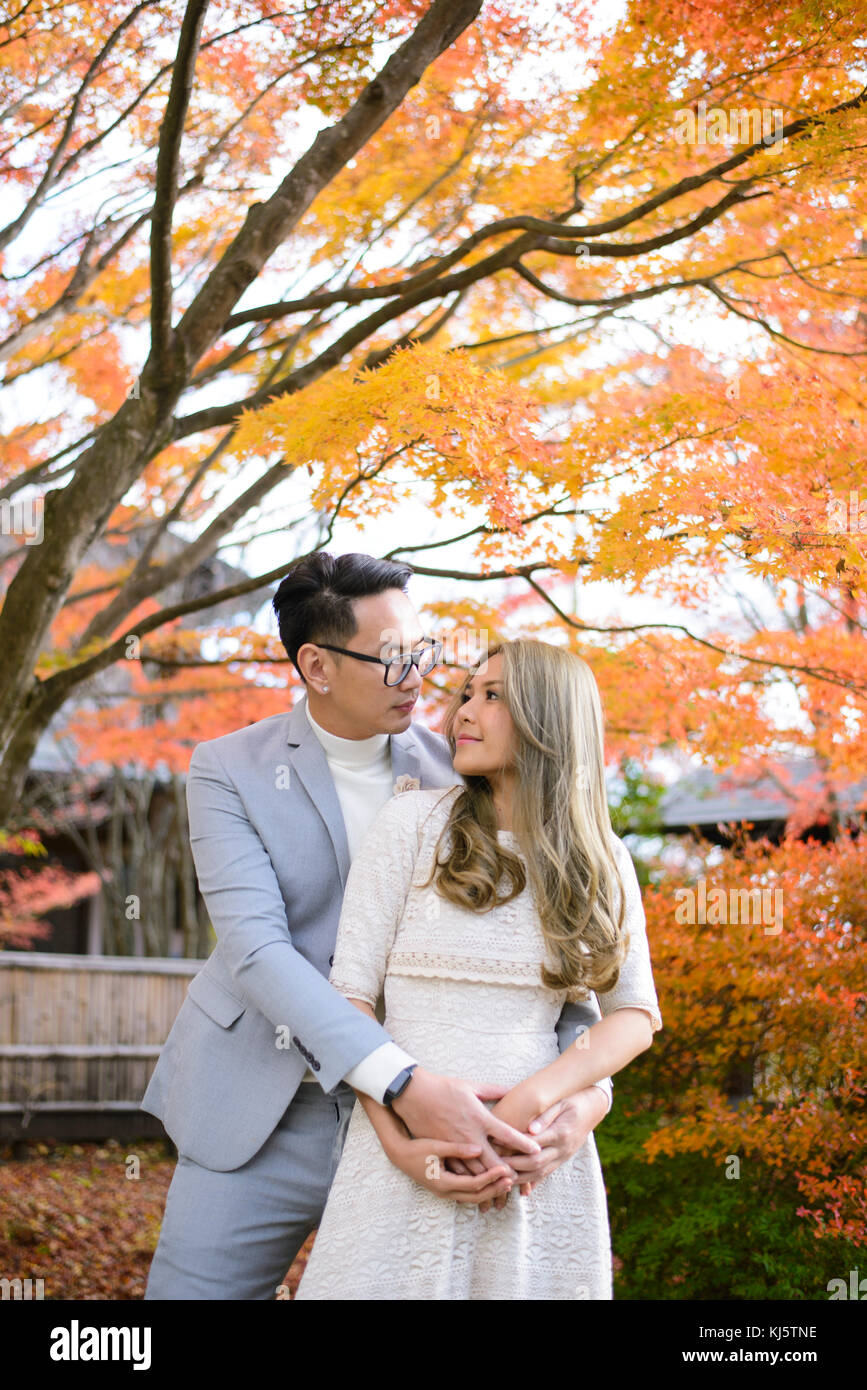 Young couple in love in the autumn park holding hands and looking at ...