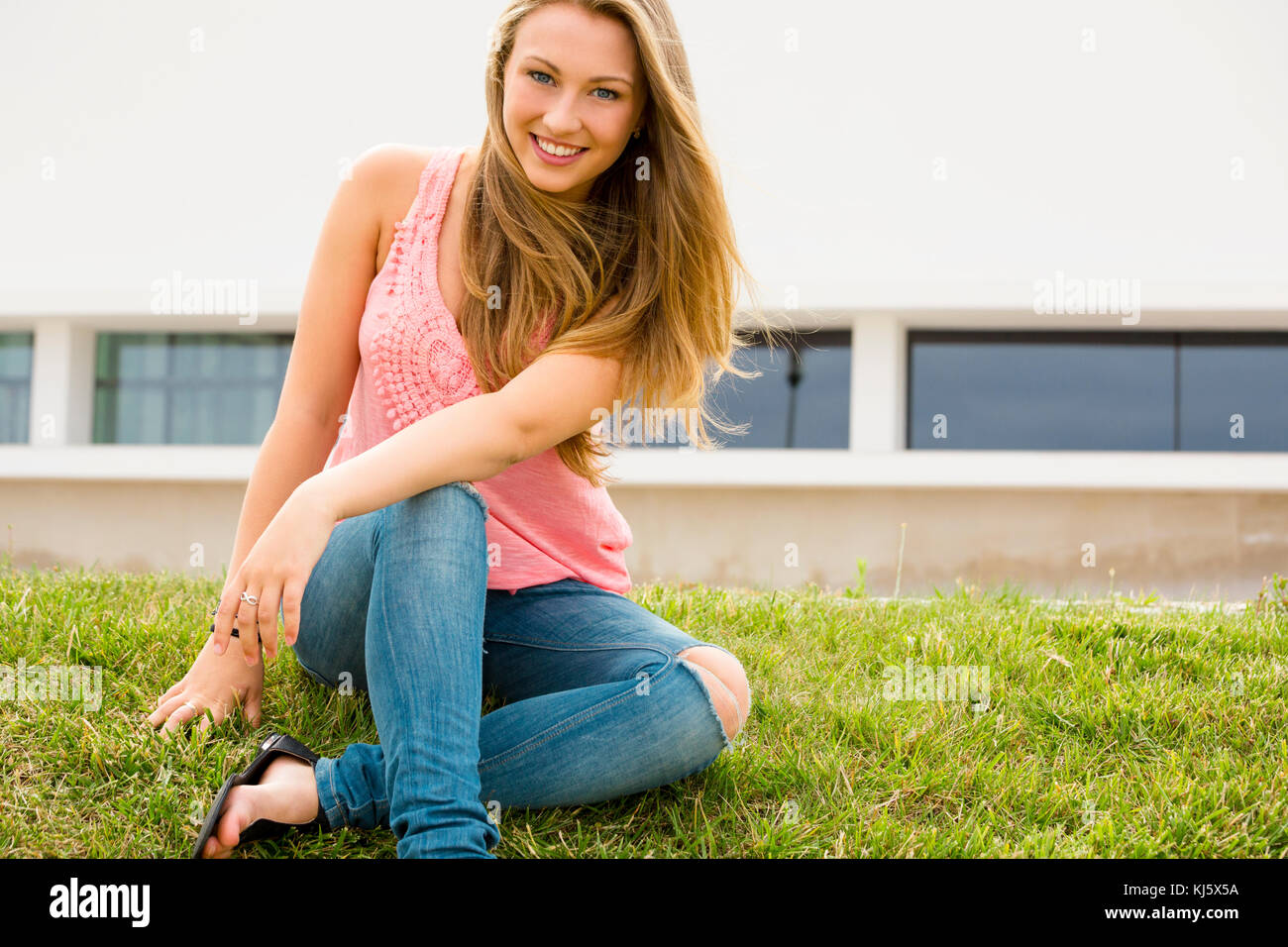 Beautiful and happy teenager sitting in the grass Stock Photo - Alamy