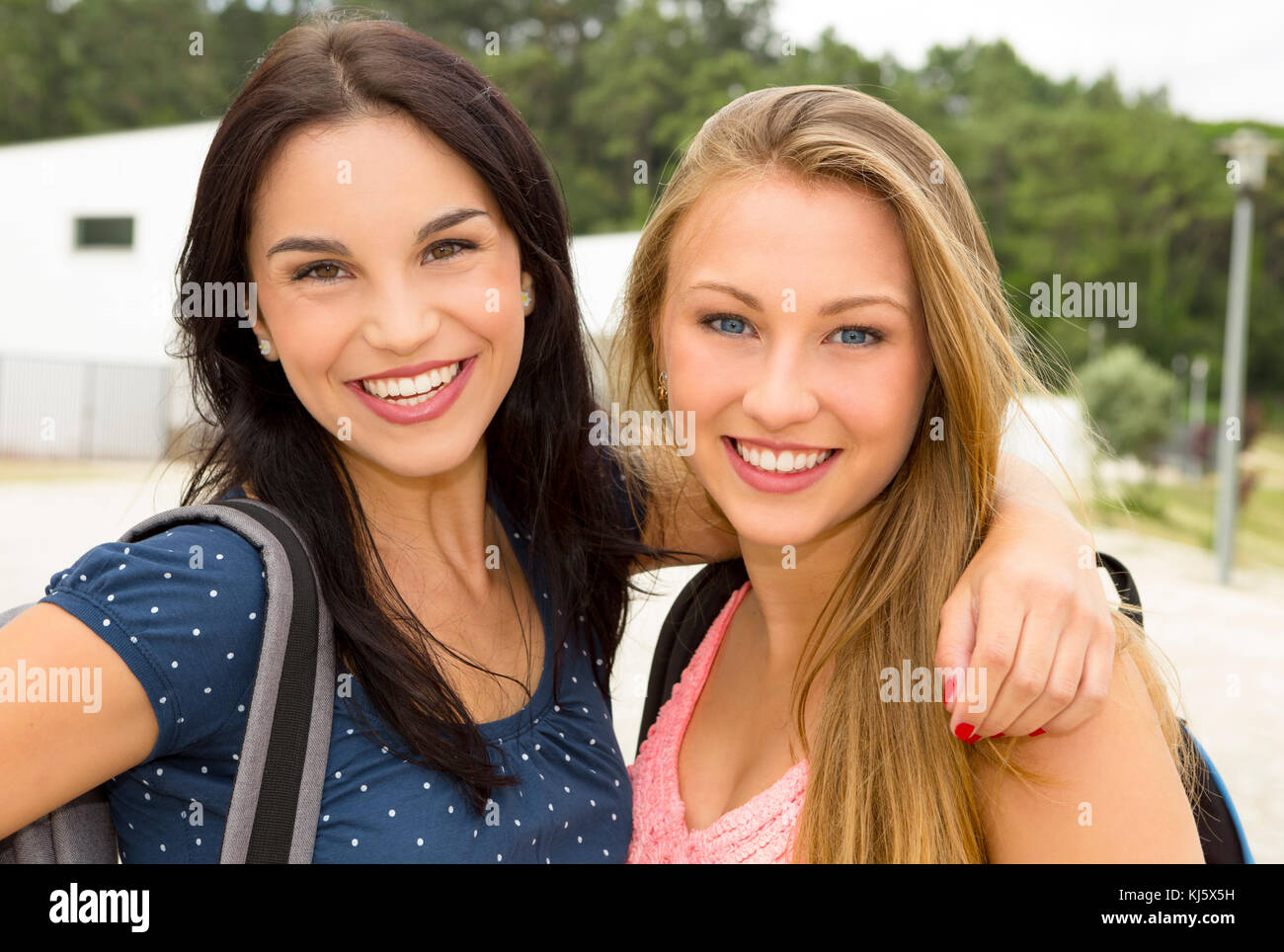 Two beautiful and happy teenage students smiling Stock Photo - Alamy