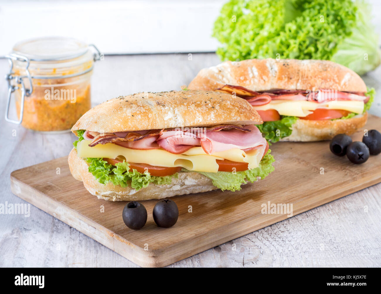 Ciabatta sandwich with bacon and cheese on wooden boarde,selective