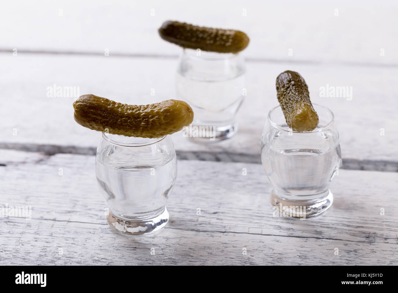 vodka shots with pickled cucumber on bar counter Stock Photo