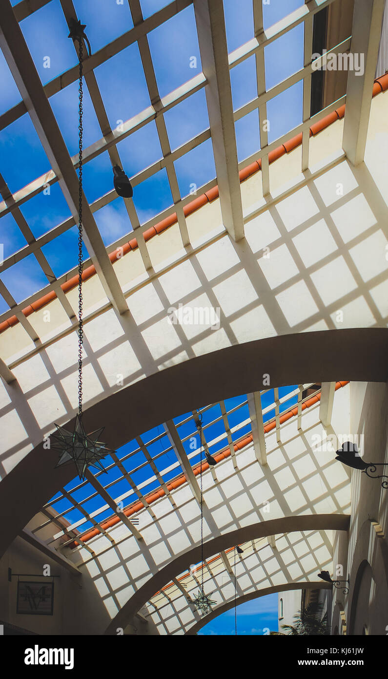 Blue Sky Through An Open Grid Ceiling With Rows Of Arches In