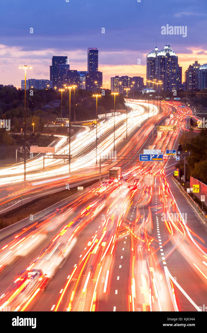 Cars leaving light trails during a long exposure along the King's Highway 401 at night in Toronto, Ontario, Canada. Stock Photo