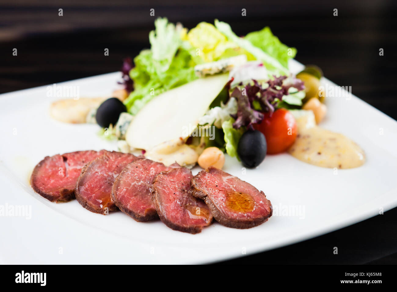 Beef fillet spiced with pear sauce and green salad Stock Photo