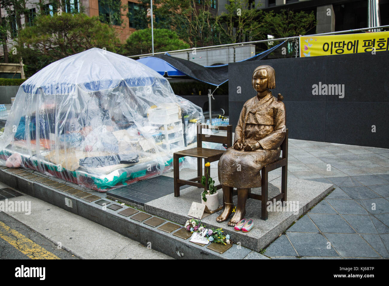 The avtivists protest beside the Statue of Peace (in Japan, called the comfort woman statue) across from the Japanese Embassy in Seoul, South Korea. Stock Photo