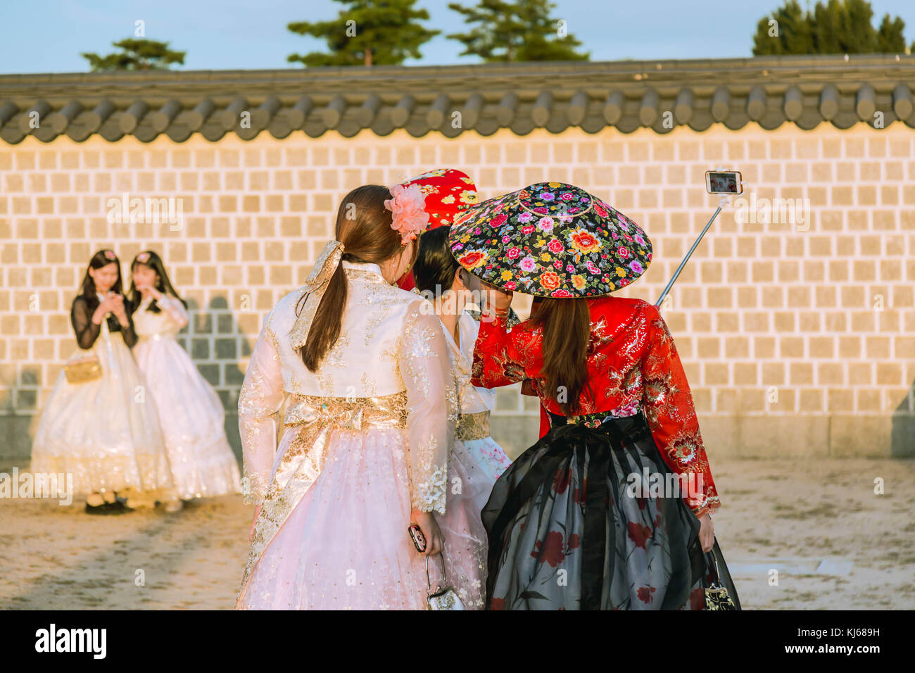 The vsitorswearing  traditional Korean outfits take selfie on the ground of Gyeongbokgung Place in Seoul, South Korea. Stock Photo