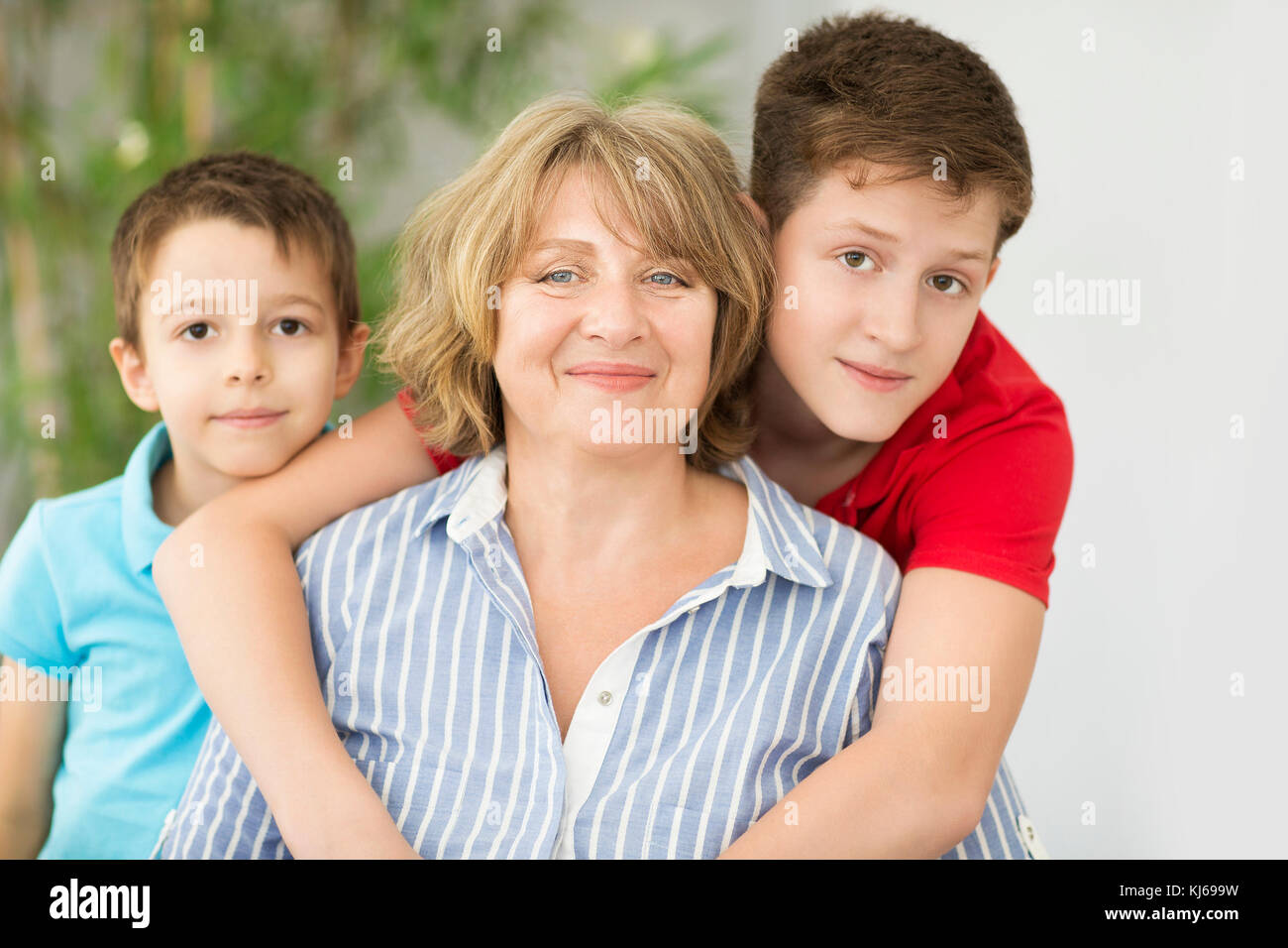 Mid-age woman with two young boys indoors. Family concept Stock Photo