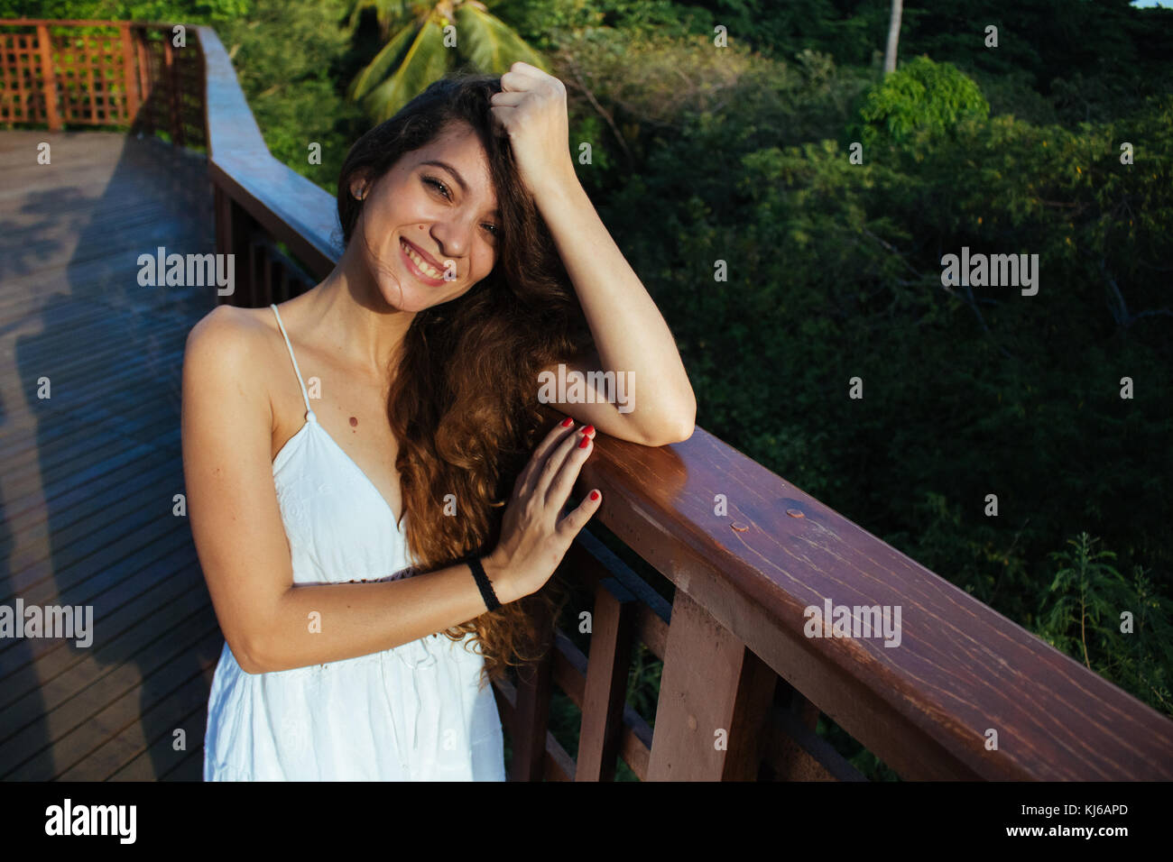 Young woman wearing white dress, on the outdoor urban park Stock Photo