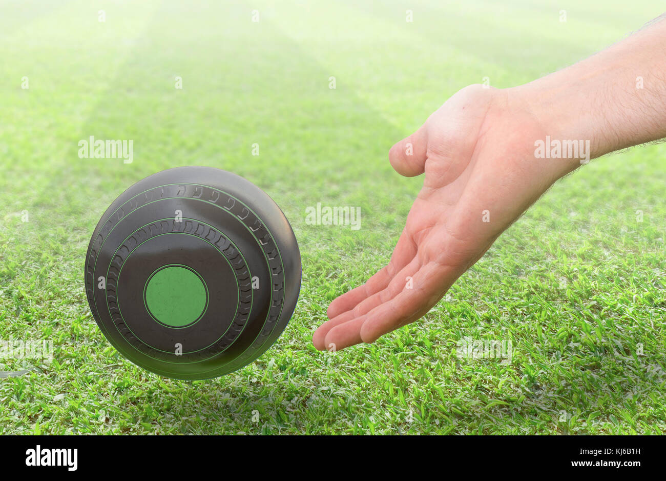 A male hand bowling and releasing a wooden lawn bowling ball on a green lawn grass surface -3D render Stock Photo