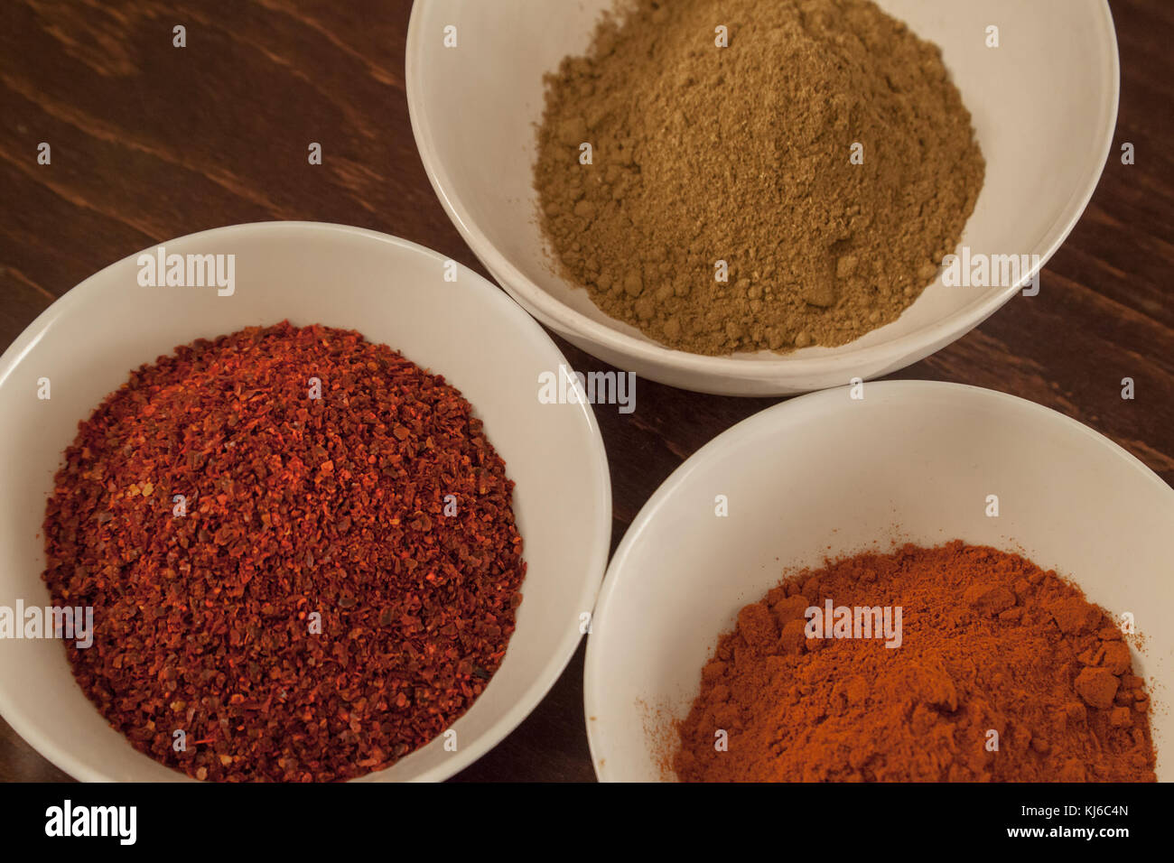 Three cups with different ethiopian spicy - red chilli and sweet pepper, berbere in background Stock Photo