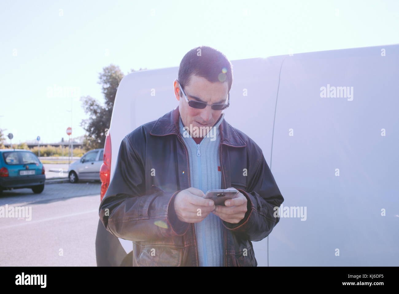 Man with casual look in outdoors checking smartphone. Stock Photo