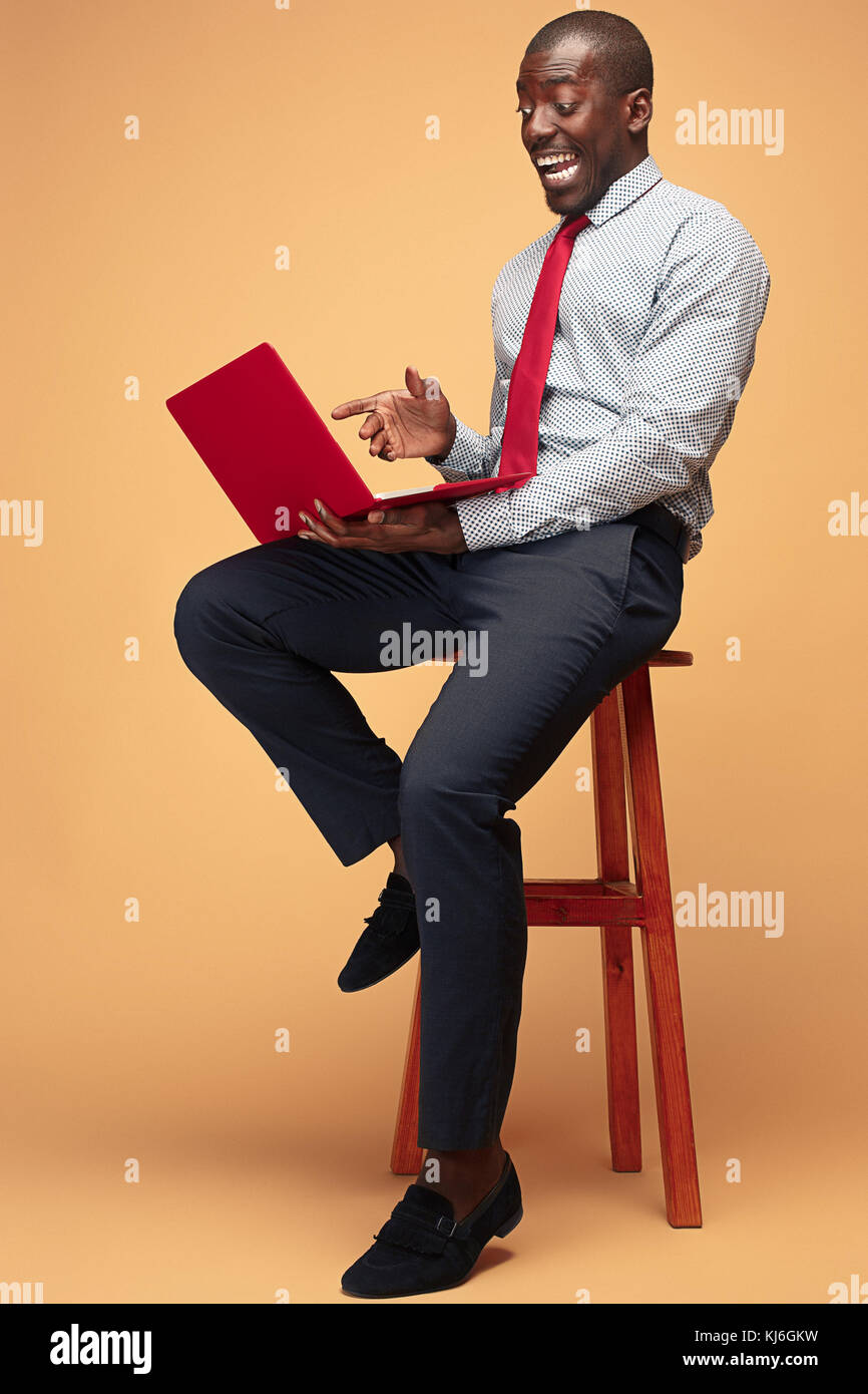 Handsome Afro American man sitting and using a laptop Stock Photo - Alamy