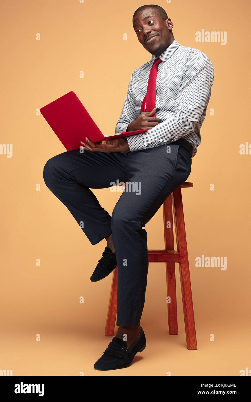 Handsome Afro American man sitting and using a laptop Stock Photo - Alamy