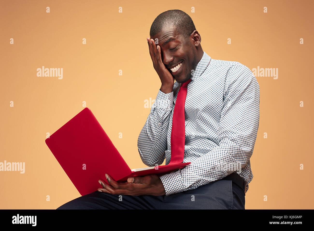 Handsome Afro American man sitting and using a laptop Stock Photo - Alamy
