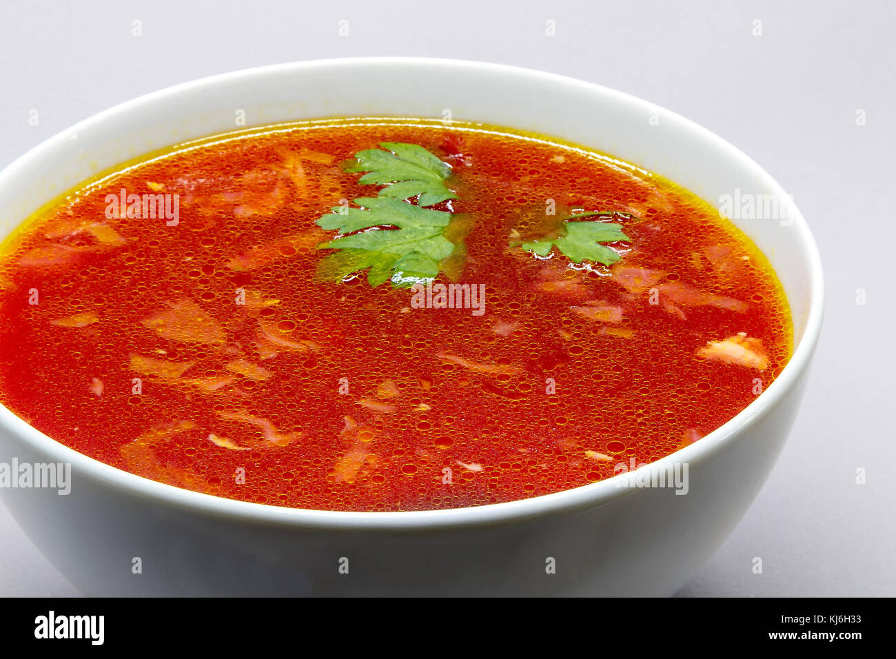 Borscht, Russian beet soup, in a white bowl. Stock Photo