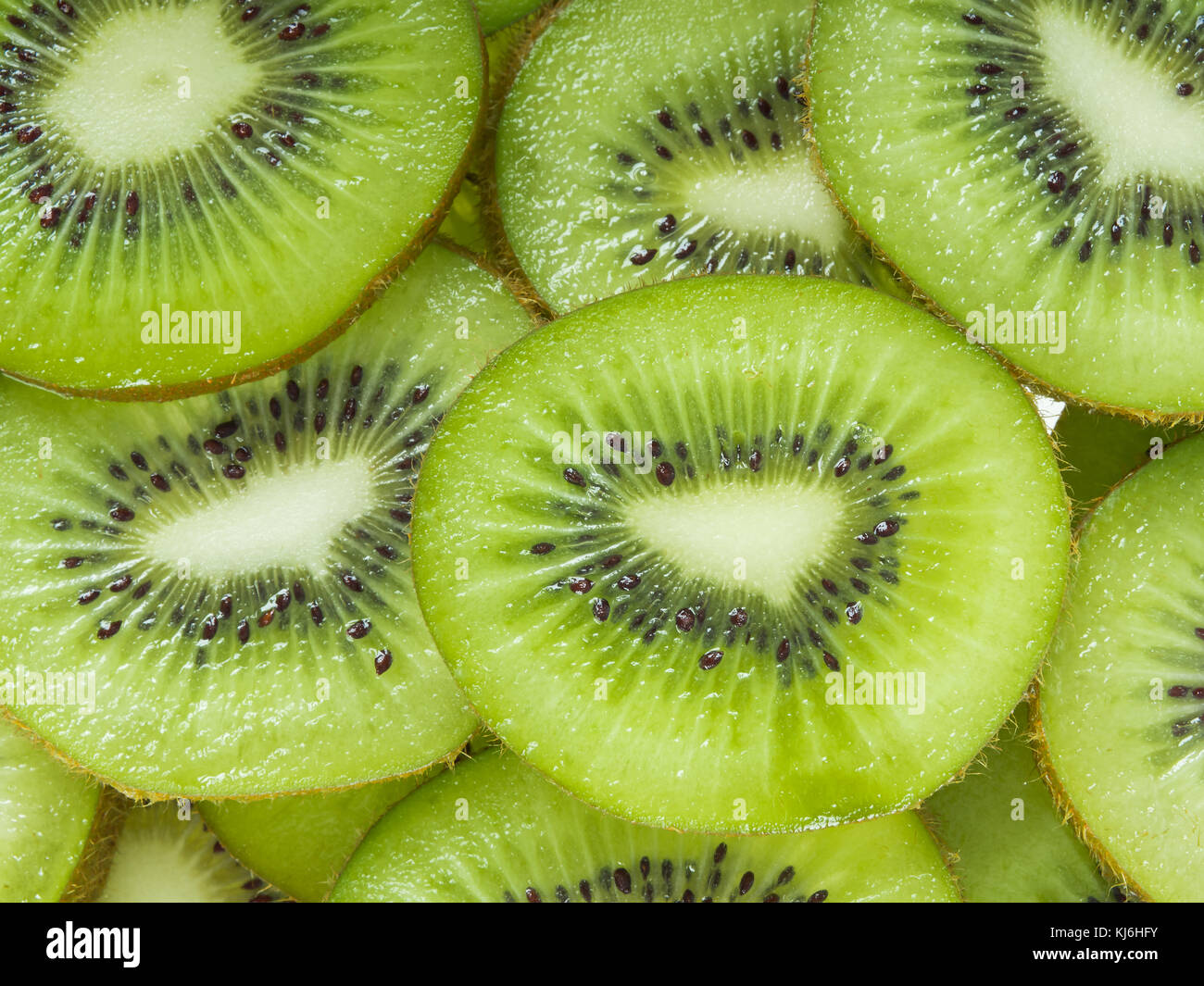 Kiwi sliced for background Stock Photo - Alamy
