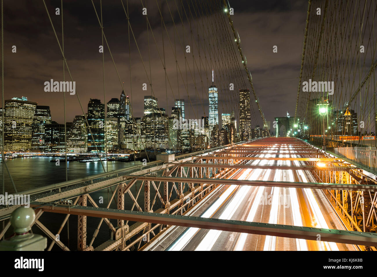USA, New York City: the city lit up at night and the Brooklyn Bridge ...