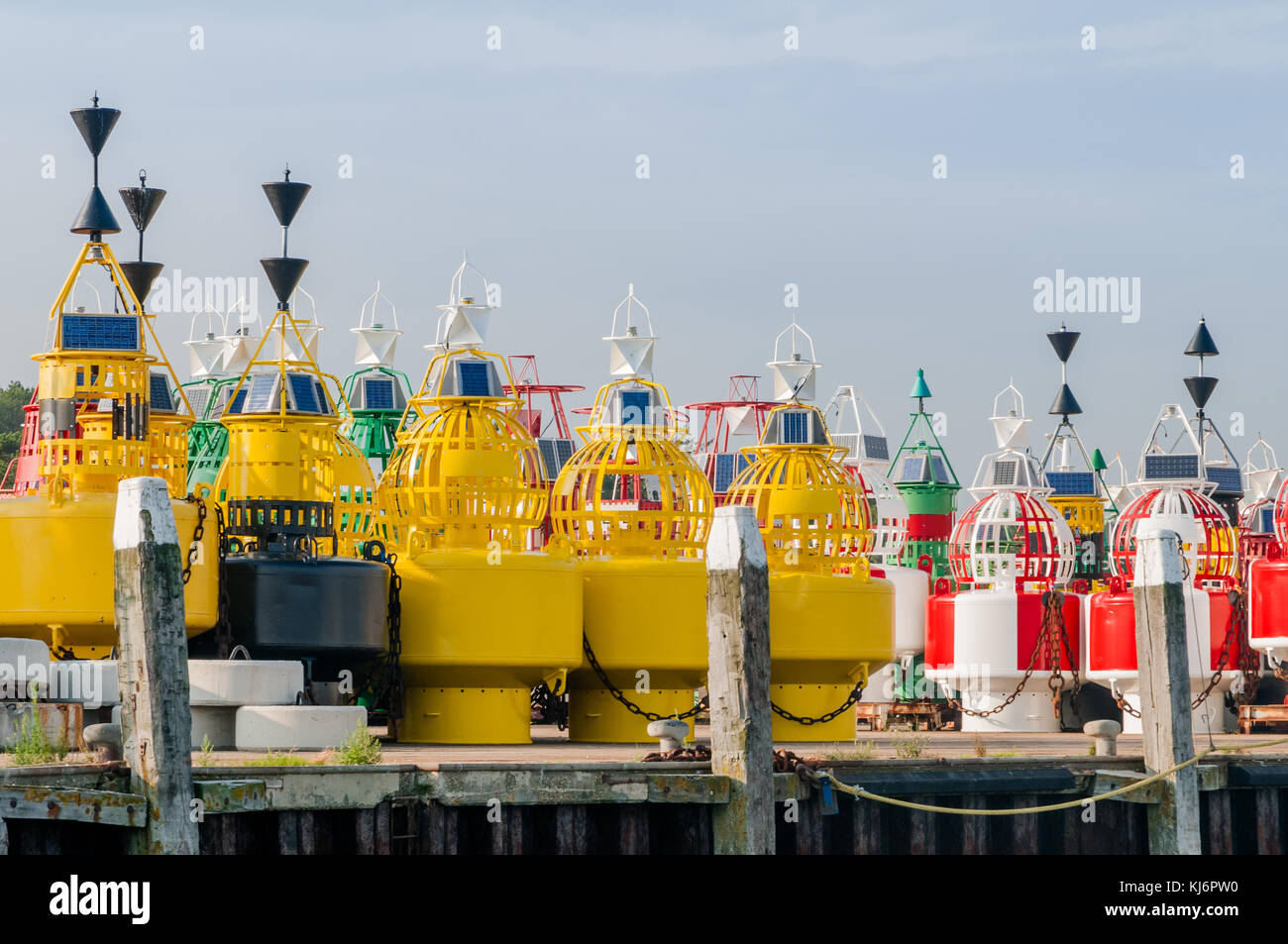 Colorful navigation buoys are standing on the quay at the depot on the dutch wadden island Terschelling. Stock Photo