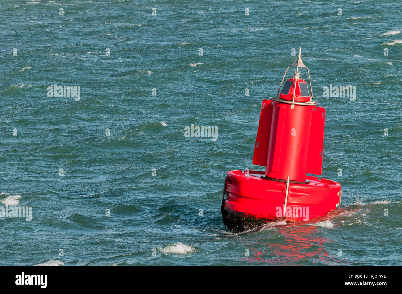 A red buoy is floating on the water surface in the Port of Rotterdam in the Netherlands. Stock Photo