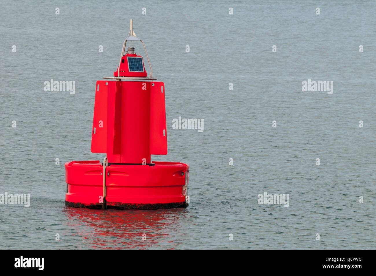 A red buoy is floating on the water surface in the Port of Rotterdam in the Netherlands. Stock Photo