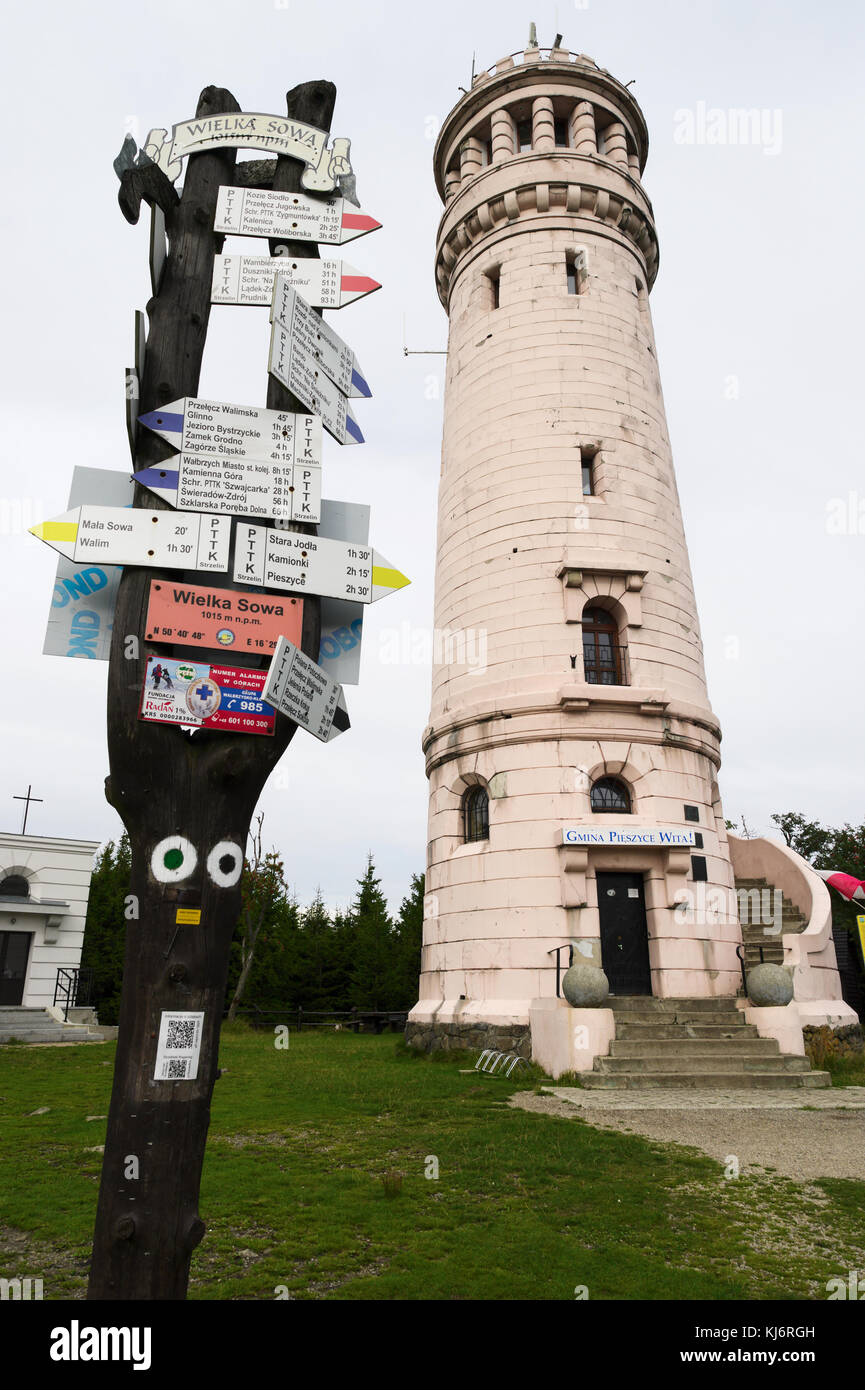 Stone viewing tower and hiking trail markers with arrow signs on Wielka Sowa (Great Owl) summit, the highest peak of The Owl Mountains, Poland Stock Photo