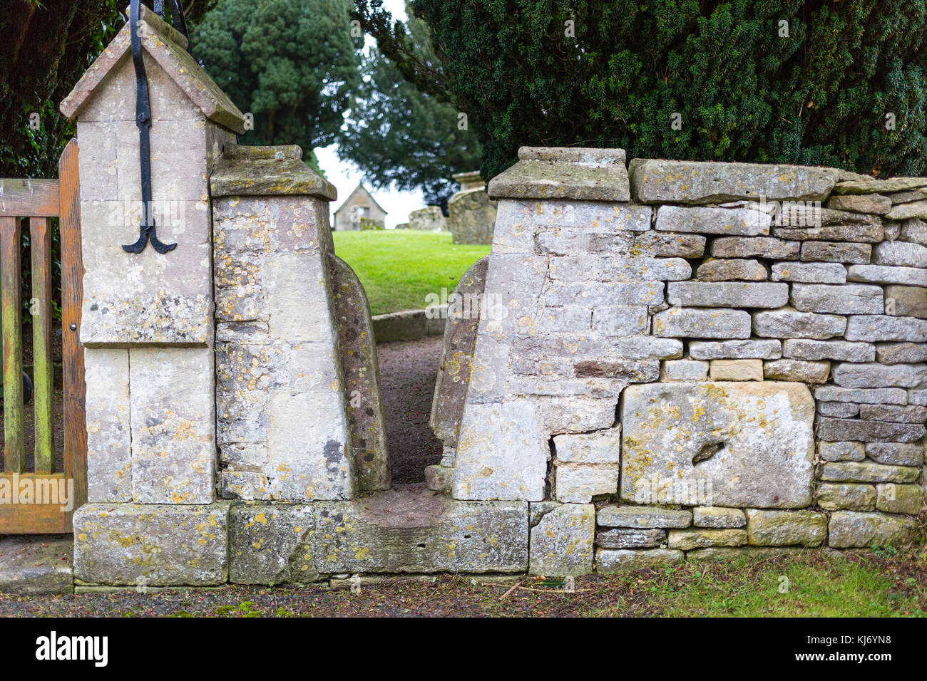 Squeeze stile in wall of St. Mary's Church, Barnsley Village, Cotswolds, Gloucestershire, UK Stock Photo