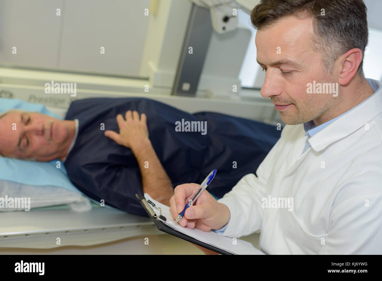 old man lying in hospital bed while doctor doing notes Stock Photo Alamy